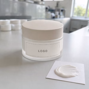Private label firming look face cream sample jar with custom label area and cream texture on a GUOCUI factory sample table