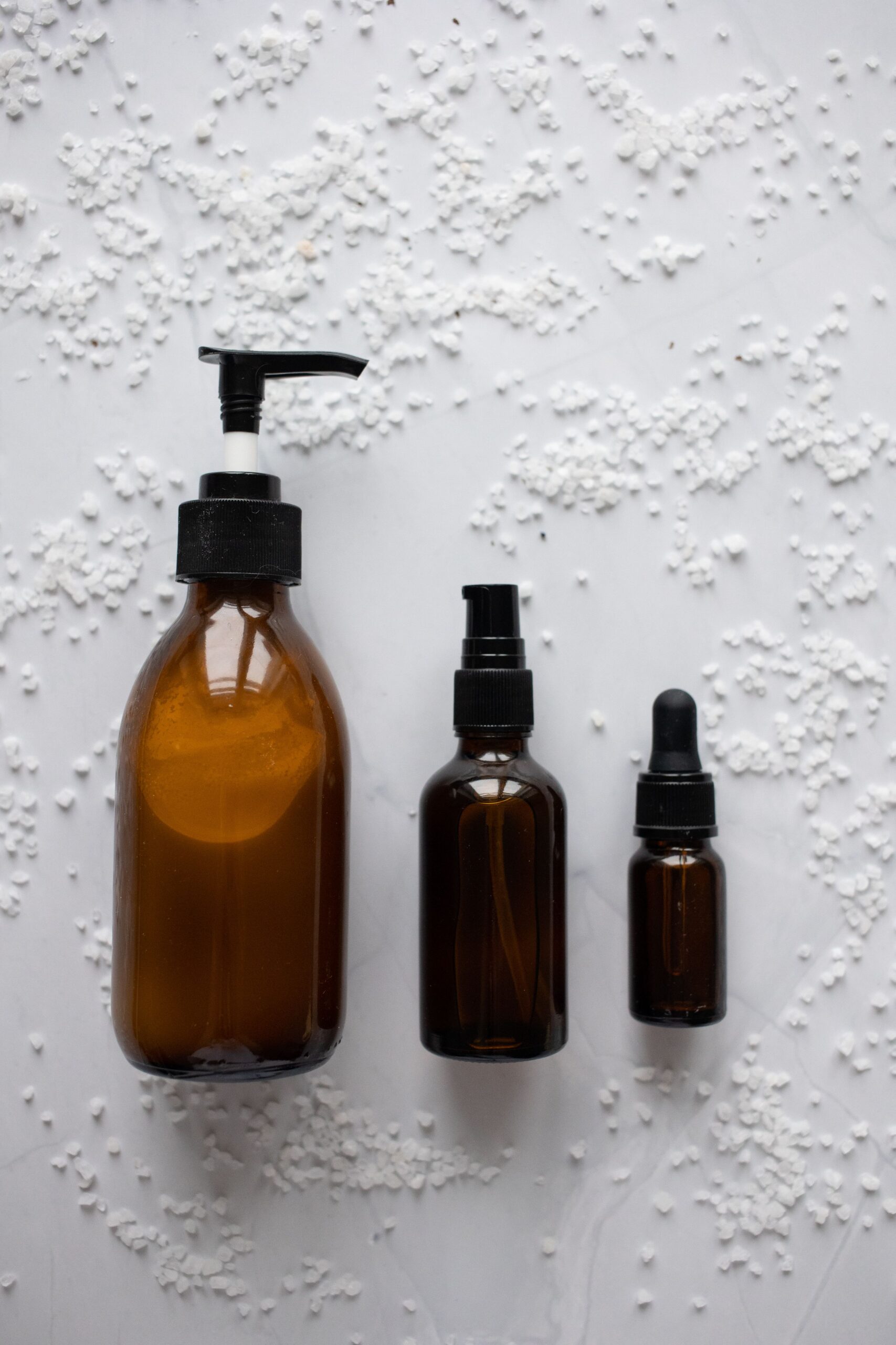 Amber pump dropper and spray bottles arranged for an EU skincare packaging brief review