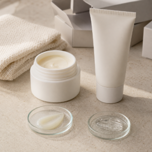 Unbranded overnight film cream jar and tube samples with translucent texture dishes on a factory sample table