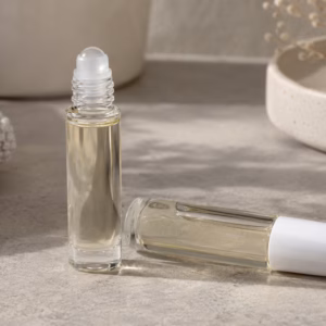 AI-generated development illustration of ordinary unbranded glass roller bottles with a hypothetical pale cosmetic oil