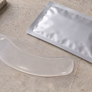 AI development illustration of a smooth pale-clear gel patch on a release liner beside a blank sachet.
